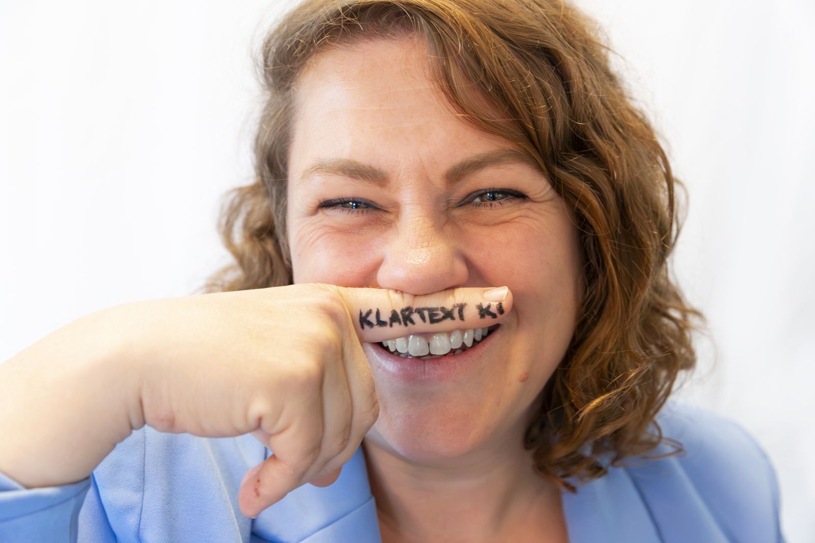 Nadine Lechner-Kari mit Finger-Schnurrbart, KLARTEXT KI auf dem Finger
